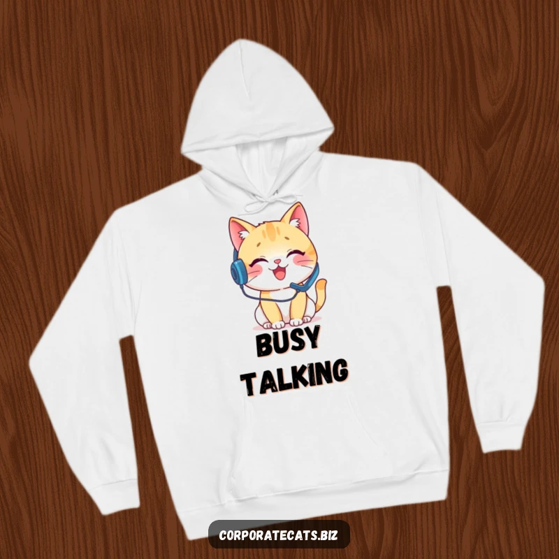 Funny hoodie with a delighted cat wearing a headset, engaged in a pretend phone call, symbolizing comfort and humor for call center agents.